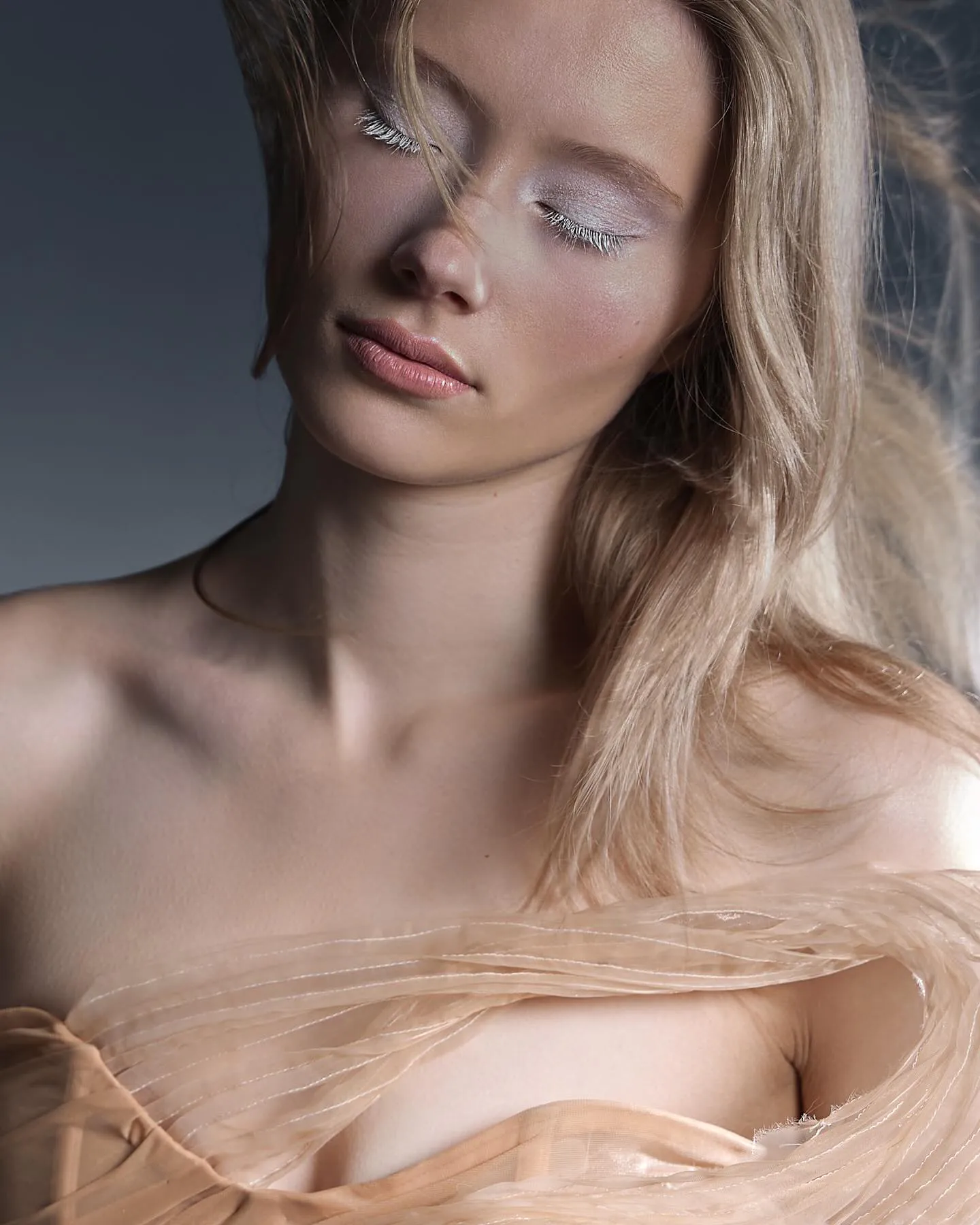 Beauty close-up met gesloten ogen, witte wimpers, glanzende huid en zachtroze lippen